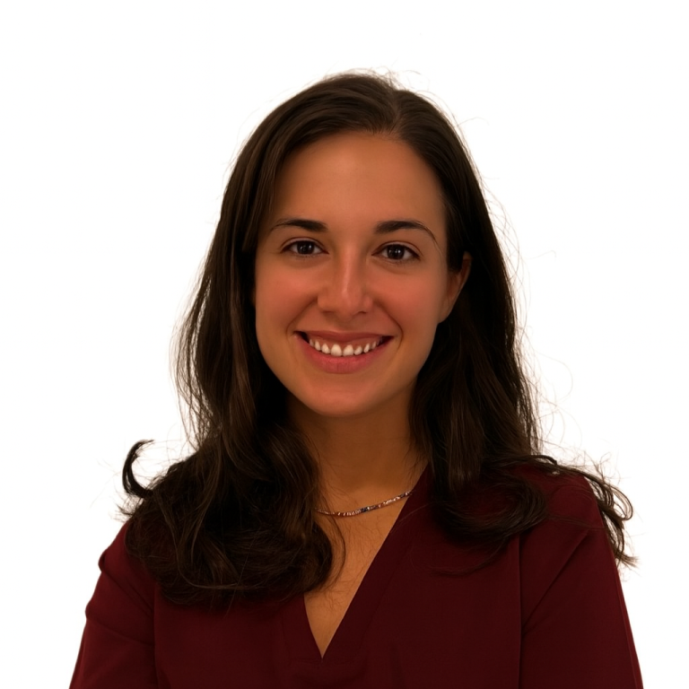 Mujer sonriente con cabello oscuro y rizado, vestida con una blusa azul.