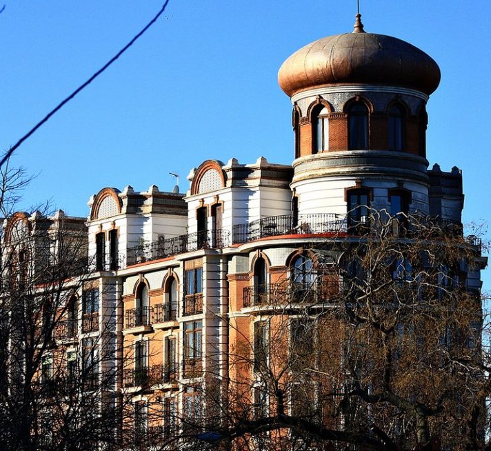 Edificio histórico con cúpula dorada y arquitectura elaborada, bajo un cielo azul.